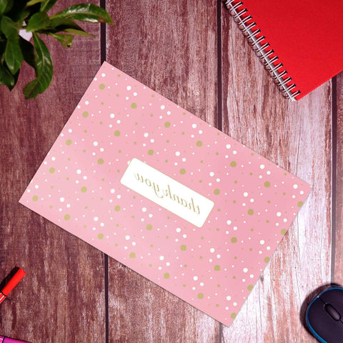 Pink Polka Dot Thank You Poly Mailer on wooden desk with stationery