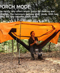 Camper enjoying UltraLight 11 Ft Hammock Shelter With Net And Rain Fly Tarp Four In One Camping Tent in porch mode in forest