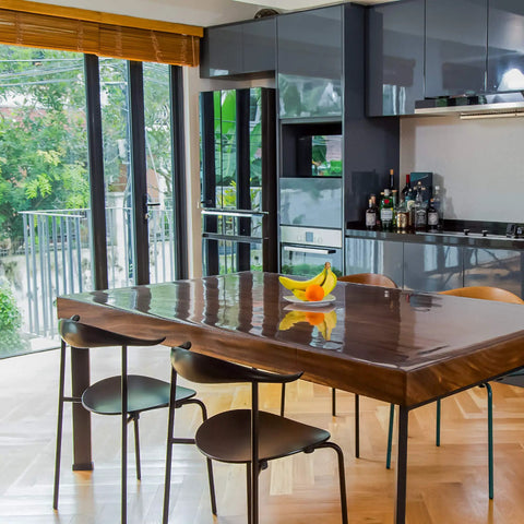 Dining room with Clear Plastic Table Cover Protector 60x36 Inches Vinyl Tabletop Shield, reflecting light on wooden table.