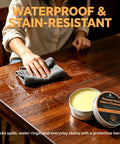 Person applying Premium Beeswax Wood Polish That Keeps Your Furniture Lookin Sharp And Ready For The Long Haul on a wooden table.