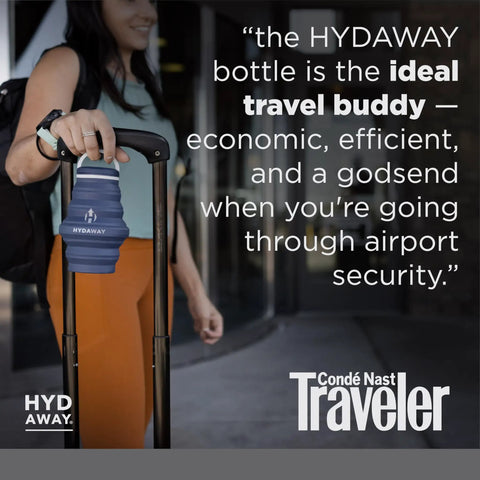 Traveler holding 25oz Collapsible Travel Water Bottle With Leakproof Flip Top Lid BPA Free attached to suitcase handle