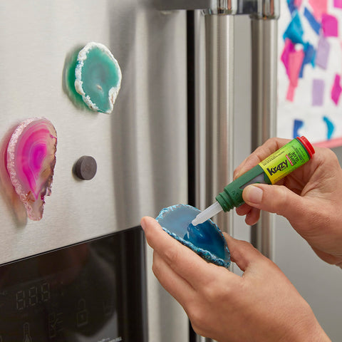 Person using Precision Control Quick Dry Super Glue Pen for Plastic Ceramic Wood Metal and More Clear Adhesive on geode magnets.