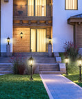 Outdoor Dusk To Dawn Post Light Lantern, 20 Inch High Bronze Lamp Post with Pier Mount illuminating a house pathway.