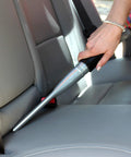 Using the Car Detailing Kit Pro With One And A Quarter Inch Vacuum Hose Accessory Set Including Orange Upholstery Tool And Aluminum Crevice Tool for Auto Seats, Ideal for tight spots.