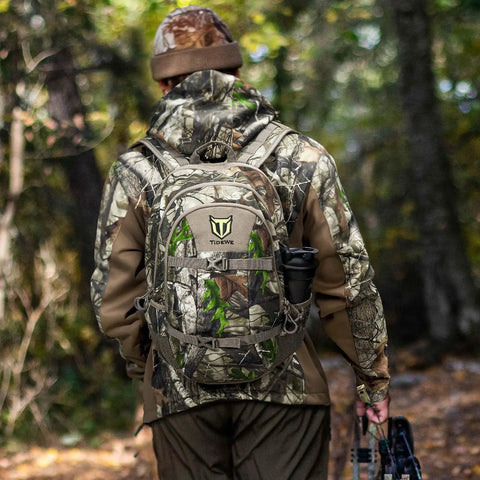 Person wearing Camo G2 25L Hunting Backpack With Waterproof Rain Cover And Tough 600D Daypack For Bow Rifle Gun in forest