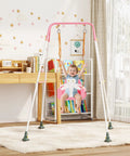 Child in pink 3-in-1 Toddler Swing Set with metal stand, indoors, nursery decor in background. Freestanding swing for baby to toddler