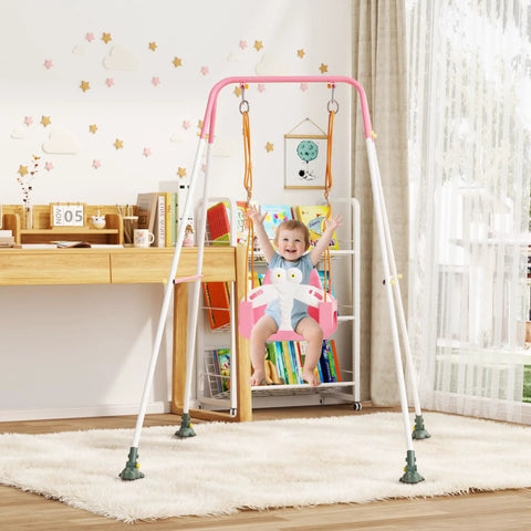 Child in pink 3-in-1 Toddler Swing Set with metal stand, indoors, nursery decor in background. Freestanding swing for baby to toddler