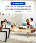 Family in living room with humidifier wick filter replacements, focus on Humidifier Wick Filter Replacement Pack Of 4 For Essick Aircare Humidifier Models B40 B40 C 3D6 100 5D6 700 7D6 100 B23 710 B23 810 D46 720 MA 0300 MA 0500 TD6 710 E27 000 E35 000 Beige in foreground.
