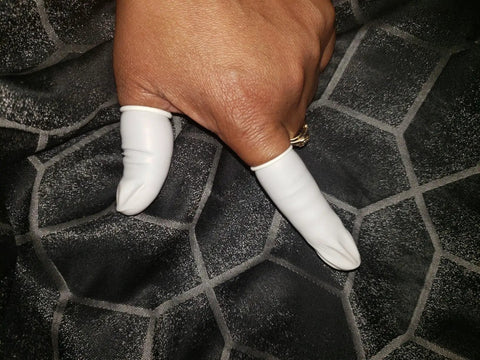 Person wearing latex finger cots disposable medium size rolled edge protectors for fingertips thumb covers 2.55 inch long