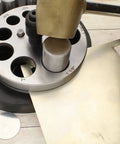 Pro Grade Heavy Duty Steel Circle Disc Cutter Set With Ten Punches and Die Cuts shown with sheet metal and punch tool