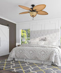 Palm Valley 52 Inch Tropical Ceiling Fan With Light installed in a bedroom, featuring five palm leaf blades and a bronze finish.