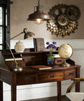 Antique office desk with vintage decor, globe, and industrial lamp, featuring gear wall art and dark wood finish.