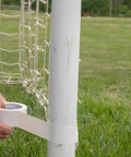 Person using White Duct Tape Roll 1.88 Inch By 20 Yards Heavy Duty For Repairs Crafting And Temporary Floor Marking Removable Cleanly Up To Three Weeks Not For Hardwood Or Direct Sunlight Single Roll on a soccer post outdoors.
