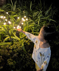 Child admiring 4 Pack Solar Fairy Lights Outdoor Waterproof Garden Decor With 40 LEDs, Flexible Iron Wire And Heavy Bulb Base