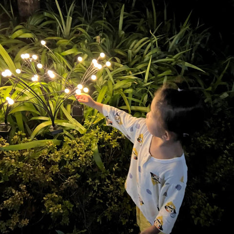 Child admiring 4 Pack Solar Fairy Lights Outdoor Waterproof Garden Decor With 40 LEDs, Flexible Iron Wire And Heavy Bulb Base
