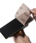 Hands attaching sandpaper to Air Powered Jitterbug Orbital Sander Kit, One Eighth Inch Orbit, 10,000 OPM, Non Vacuum, includes extra pad.