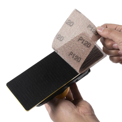 Hands attaching sandpaper to Air Powered Jitterbug Orbital Sander Kit, One Eighth Inch Orbit, 10,000 OPM, Non Vacuum, includes extra pad.