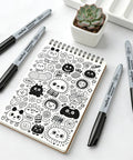 Bulk Black Permanent Markers 150 Pack With Fine Point Tips For Office And Moving shown with doodles on a notebook
