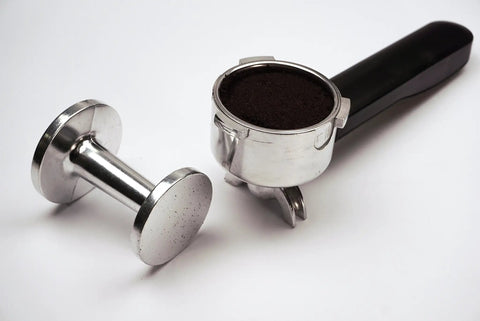 Pro Grade Dual Sided Espresso Tamper With Durable Aluminum Alloy Construction beside an espresso portafilter