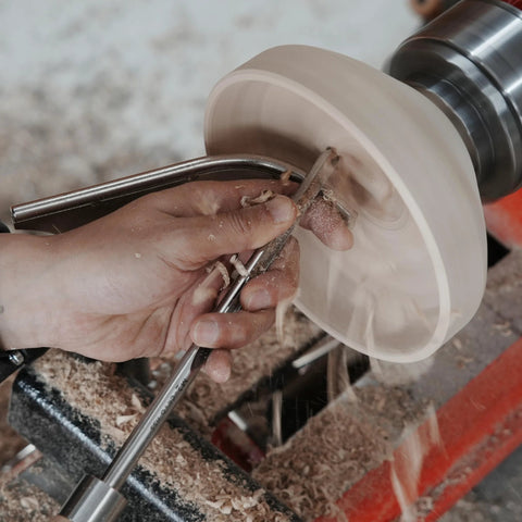 Woodturning tool with 1-inch stem used on a spinning wooden bowl on a lathe