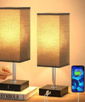 Set Of 2 Bedside Lamps With Dual USB Ports, Small Nightstand Table Lamps With Black Fabric Shade For End Tables shown lit on books