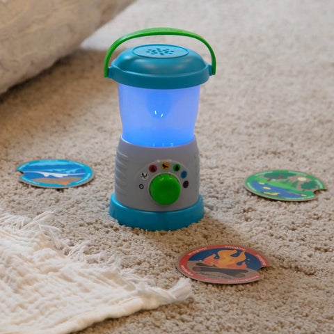 Durable Light And Sound Camping Lantern Toy With Six Color Modes and scene cards on carpet for kids' pretend play.