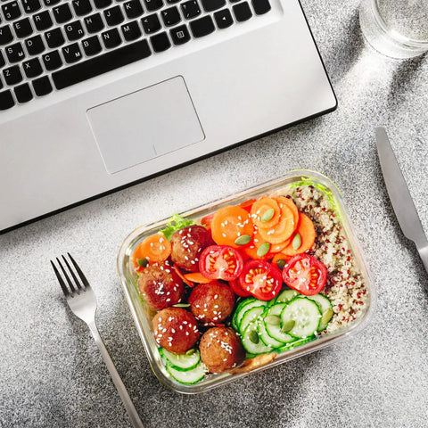 Glass Food Storage Set With 24 Pieces And Upgraded Snap Lock Lids For Meal Prep on table with salad near laptop and cutlery