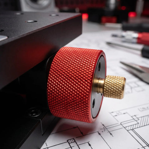 Close-up of heavy duty manual pivot angle platform knob, featuring red anodized aluminum for precise adjustments.