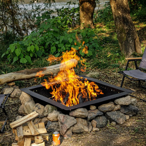 Heavy Duty 36 Inch Square Fire Pit Ring for DIY Campfire Inserts, surrounded by stones, in a natural setting with chairs.