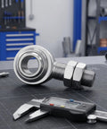 3/4 Inch Steel Heim Joint Rod End With Two Nuts And Right Hand Thread For Quick Installation on workbench with caliper.