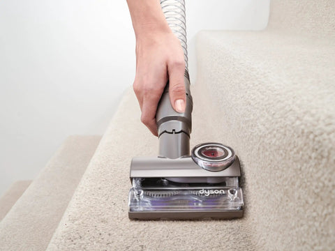 Hand using Tangle Free Turbine Upholstery Tool For DC77 And UP17 Cinetic Big Ball Animal And Allergy Uprights on carpeted stairs.