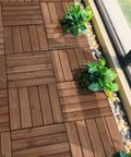Interlocking Patio Deck Tiles 12x12 Inch Wood Floor Tiles Outdoor Flooring for Patio Garden Deck Poolside Brown All Weather Fir Wood PVC With Easy Snap Lock System No Hassle Setup Durable Exterior Flooring, installed with greenery border.