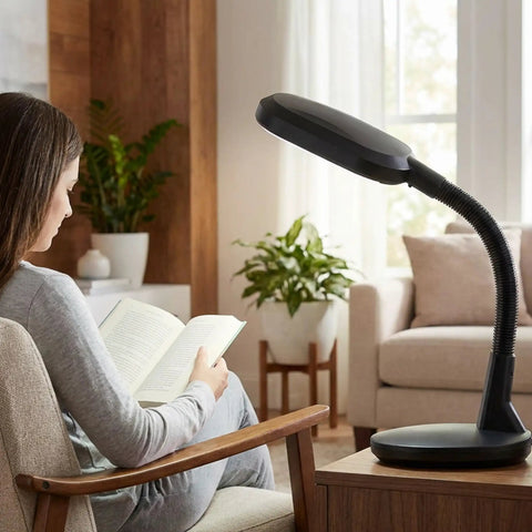 Natural Daylight Desk Lamp With Adjustable Gooseneck For Reading Working Crafting Sewing Or Homework Eye Strain Relief 6400K 27W Light For Dorm And Office Black next to a person reading.