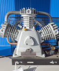 Close-up of a Built Tough Cast Iron Air Compressor with four-way manifold block, showing detailed machined inner threads and ports.