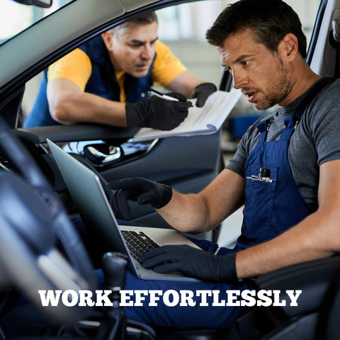 Black disposable nitrile gloves worn by a mechanic using a laptop inside a car workshop