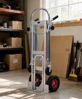 Premium Aluminum 3 In 1 Convertible Dolly Cart And 1000 Lb Hand Truck in garage with red wheels and swivel casters.