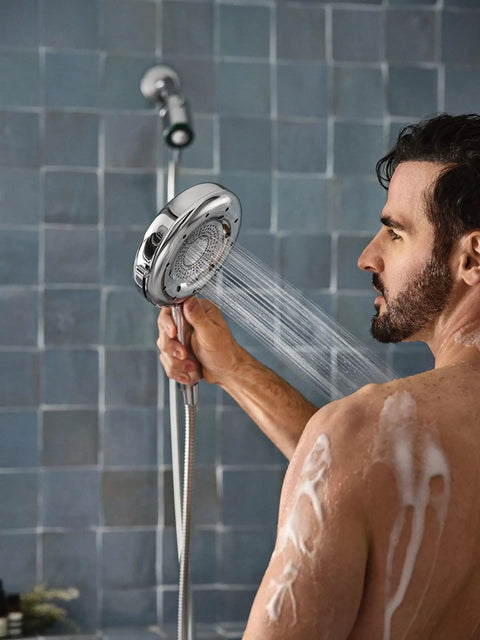 Person using Quattro Handheld Shower System With Four Modes Relieve Soothe Clarify Cleanse Magnetix Dock Chrome Finish