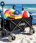 Heavy Duty Beach Wagon With Big Wheels For Sand Go-To Collapsible Utility Cart loaded with beach gear on sand