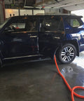 Car in garage with Shop Vacuum Garage Kit With 30 Foot Commercial Grade Hose for non clog airflow connected to rear door.
