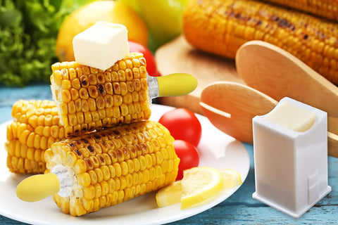 Grilled corn with butter on plate using twin prong corn cob holders and butter spreader set for barbecue safe grip stainless steel skewers