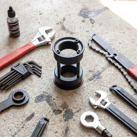 American To European Bottom Bracket Adapter Kit Black Metal BB Conversion surrounded by tools on concrete surface