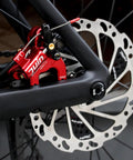 Rock Solid Flat Mount Disc Brake Set With 160mm Rotors For Road And Gravel Bikes featuring red caliper and silver rotor.