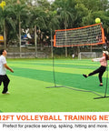 Portable 12ft Volleyball Training Net For Hitting And Serving Drills set up outdoors with two players.