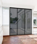 Heavy Duty Magnetic Screen Door With Self Sealing Magnets Hands Free Insect Shield For Patio And Bedroom Sliding Doors Up To 60 By 80 Inches Durable Fiberglass Mesh Black installed on sliding door in bright room.