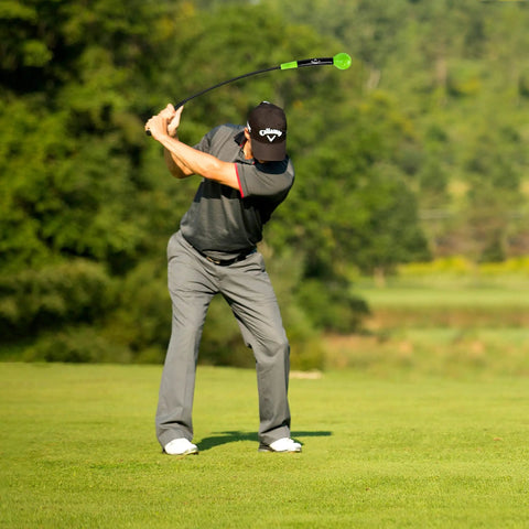 Golfer using Lag Trainer For Golf Swing Practice And Warmup, Tempo Drill To Build Consistency on a green fairway