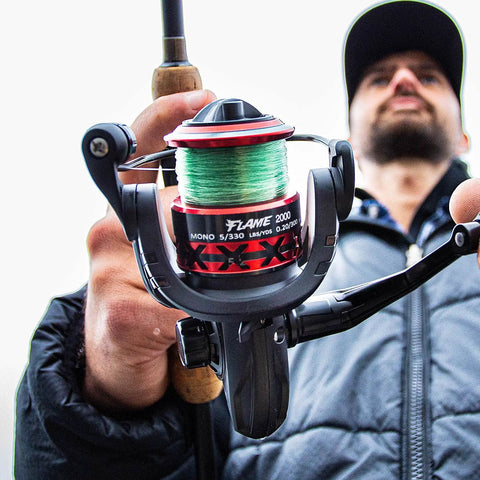 Man holding Lightweight Flame Spinning Reel With Ultra Smooth 9 Plus 1BB Technology Carbon Fiber Frame 19.8 Lb Max Drag 1000 Series