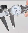 Hand holding dial caliper with 0-6 inch range, precision to 0.001 inch, measures inside, outside, depth and step, durable black body.
