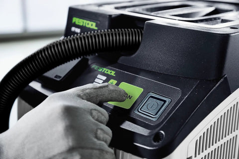 Close-up of CT 15 Dust Extractor with HEPA Filtration, Auto Start button highlighted for operation, showing user interaction.