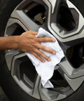 Hand using Bulk Cotton T Shirt Rags 5 Lb Box For Auto Shop Cleaning Low Lint Wiping Cloths For Paint Grease Stain Removal on car wheel