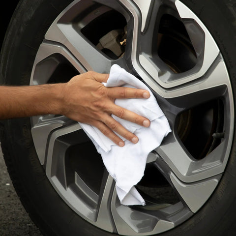 Hand using Bulk Cotton T Shirt Rags 5 Lb Box For Auto Shop Cleaning Low Lint Wiping Cloths For Paint Grease Stain Removal on car wheel